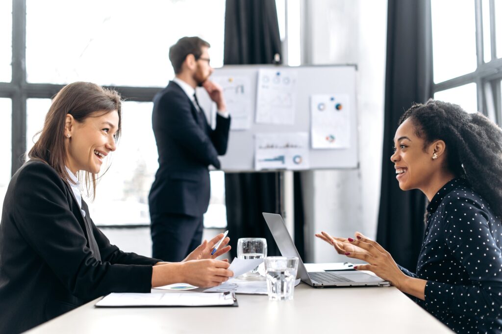 Two successful confident women are negotiating, discussing business project, planning financial